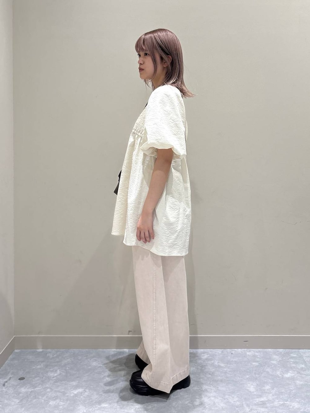 ピンク系のデニムパンツ、ブラウン系のローファー、ブラウン系のトートバッグを着用したレディースの春コーディネートの2枚目の写真