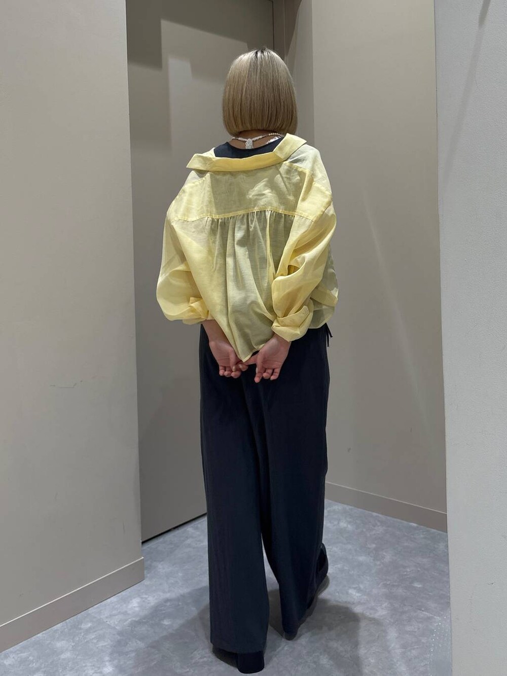 ホワイト系のTシャツ/カットソー、イエロー系のシャツ/ブラウス、ブラック系のサンダルを着用したレディースの春コーディネートの3枚目の写真