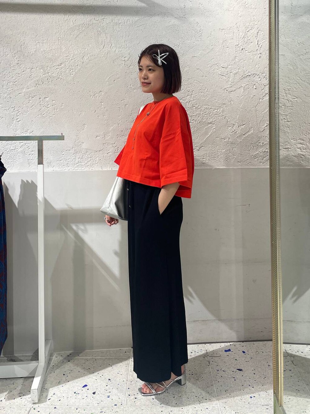 ブラック系のスカート、シルバー系のサンダル、レッド系のTシャツ/カットソーを着用したレディースの春コーディネートの2枚目の写真