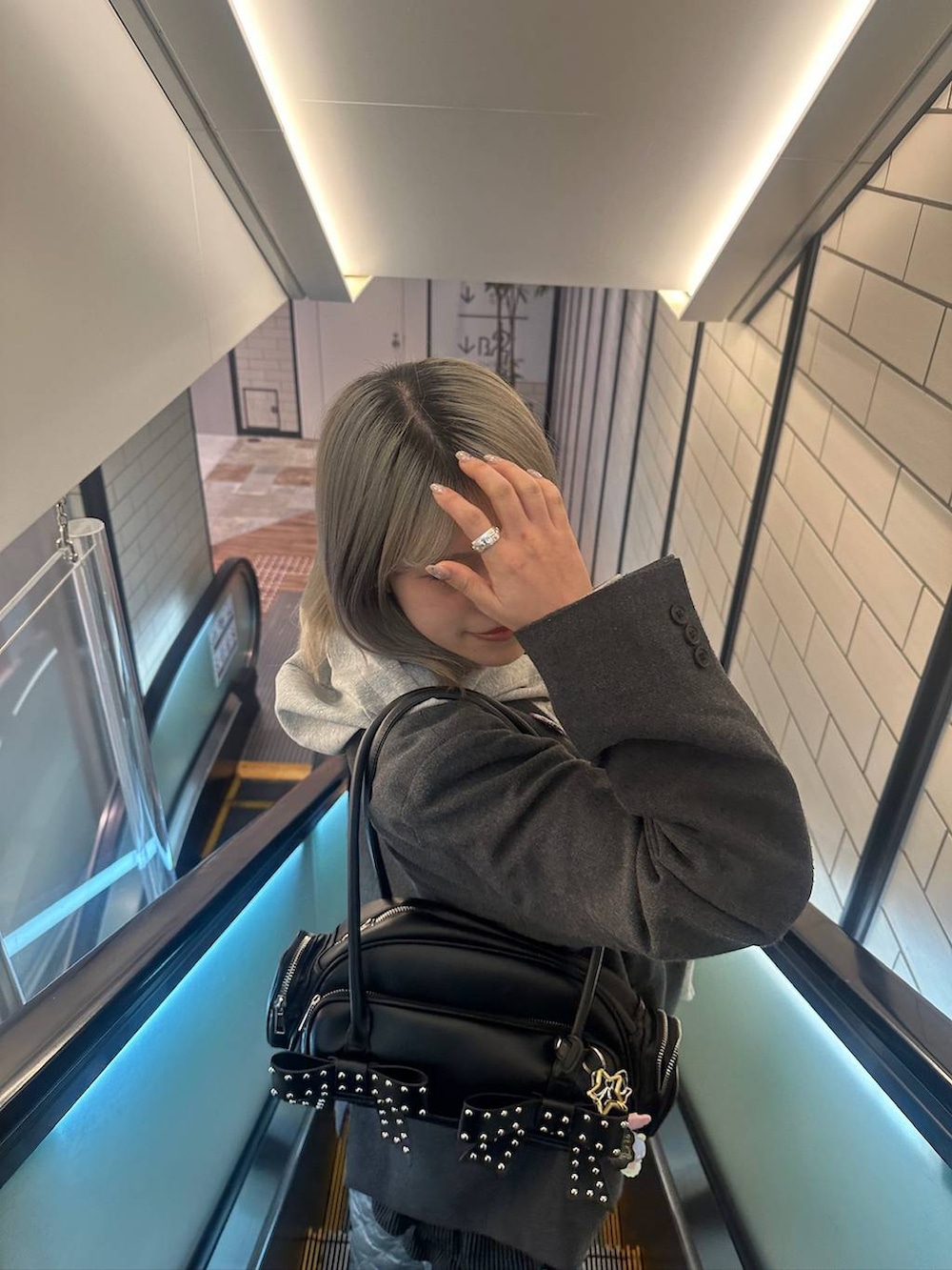 グレー系のテーラードジャケット、グレー系のパーカーを着用したレディースの冬コーディネートの3枚目の写真