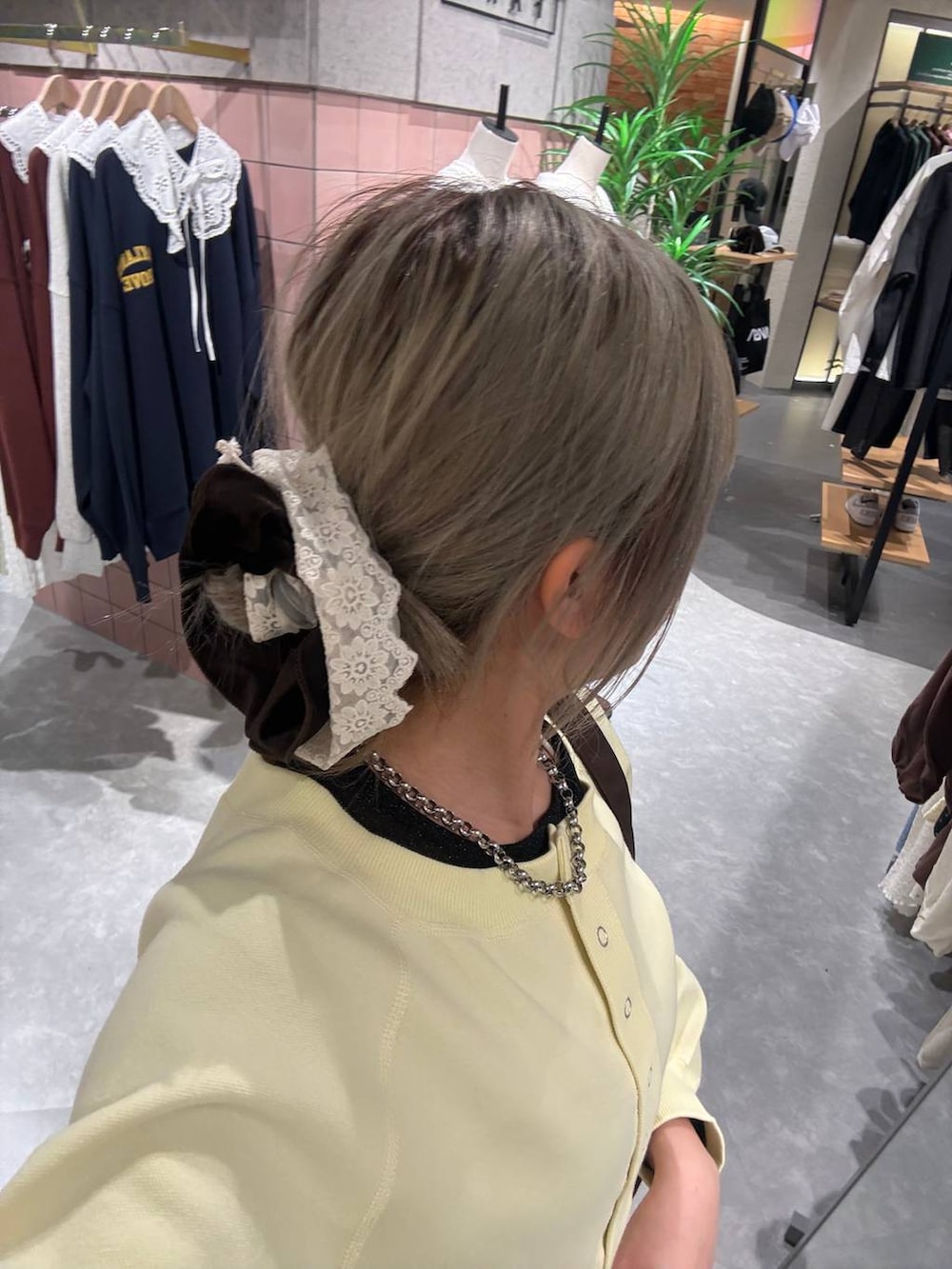 イエロー系のスウェット、ブラック系のTシャツ/カットソー、その他のネックレスを着用したレディースの冬コーディネートの3枚目の写真