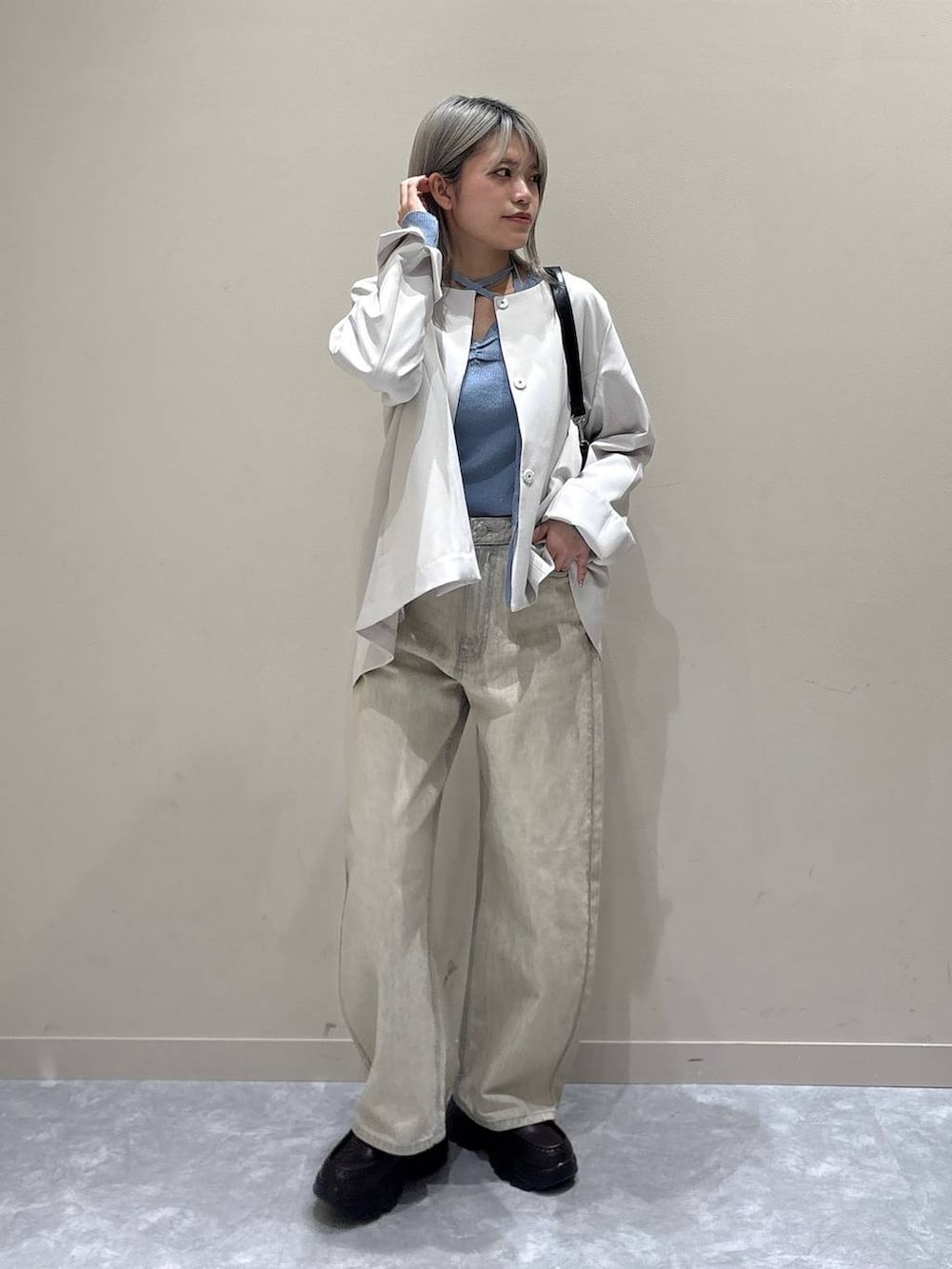 ベージュ系のデニムパンツ、ホワイト系のテーラードジャケット、ブラック系のショルダーバッグを着用したレディースの冬コーディネートの5枚目の写真