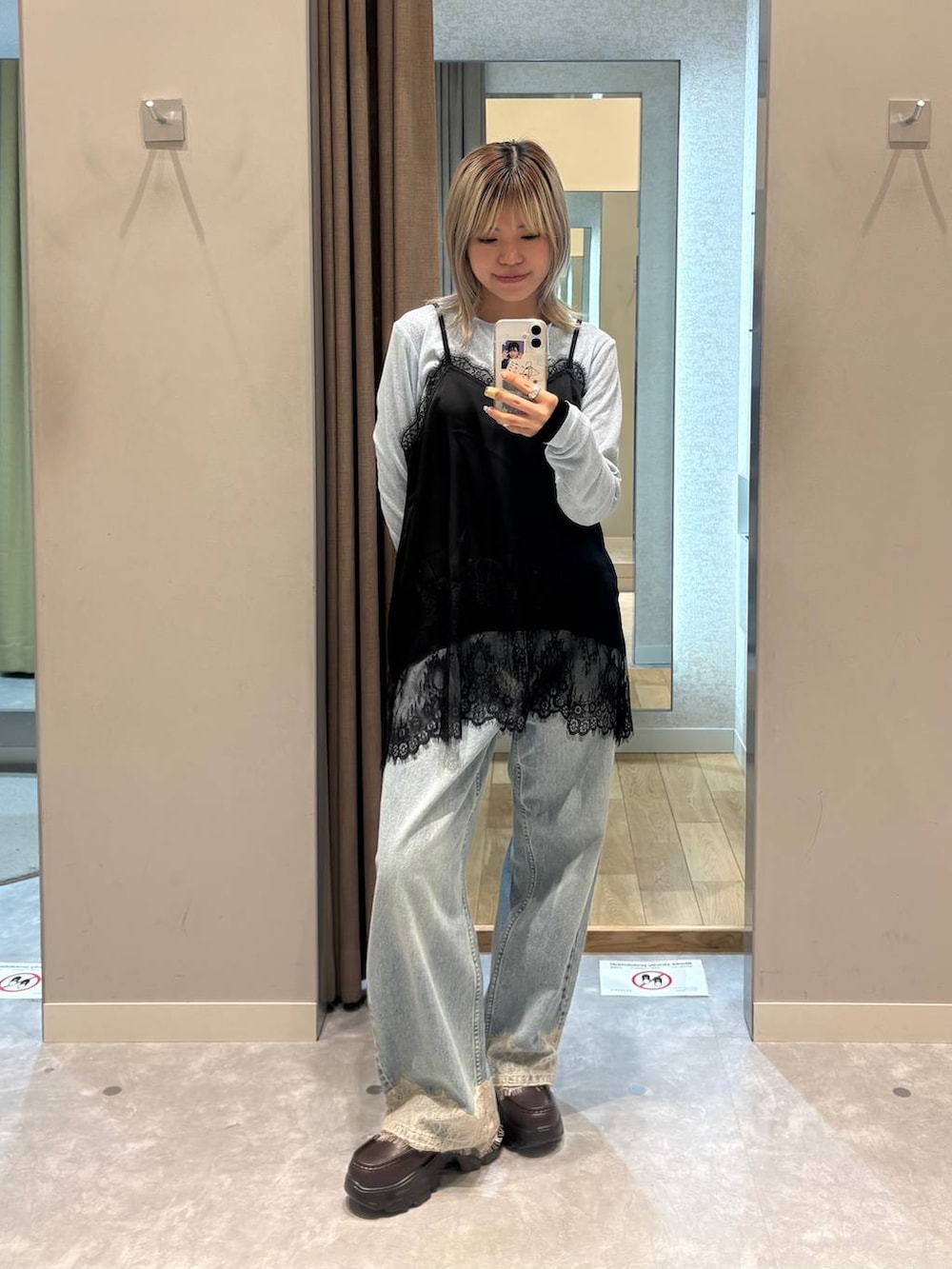 ブラック系のニット/セーター、ブルー系のデニムパンツ、ブラック系のローファーを着用したレディースの春コーディネートの2枚目の写真