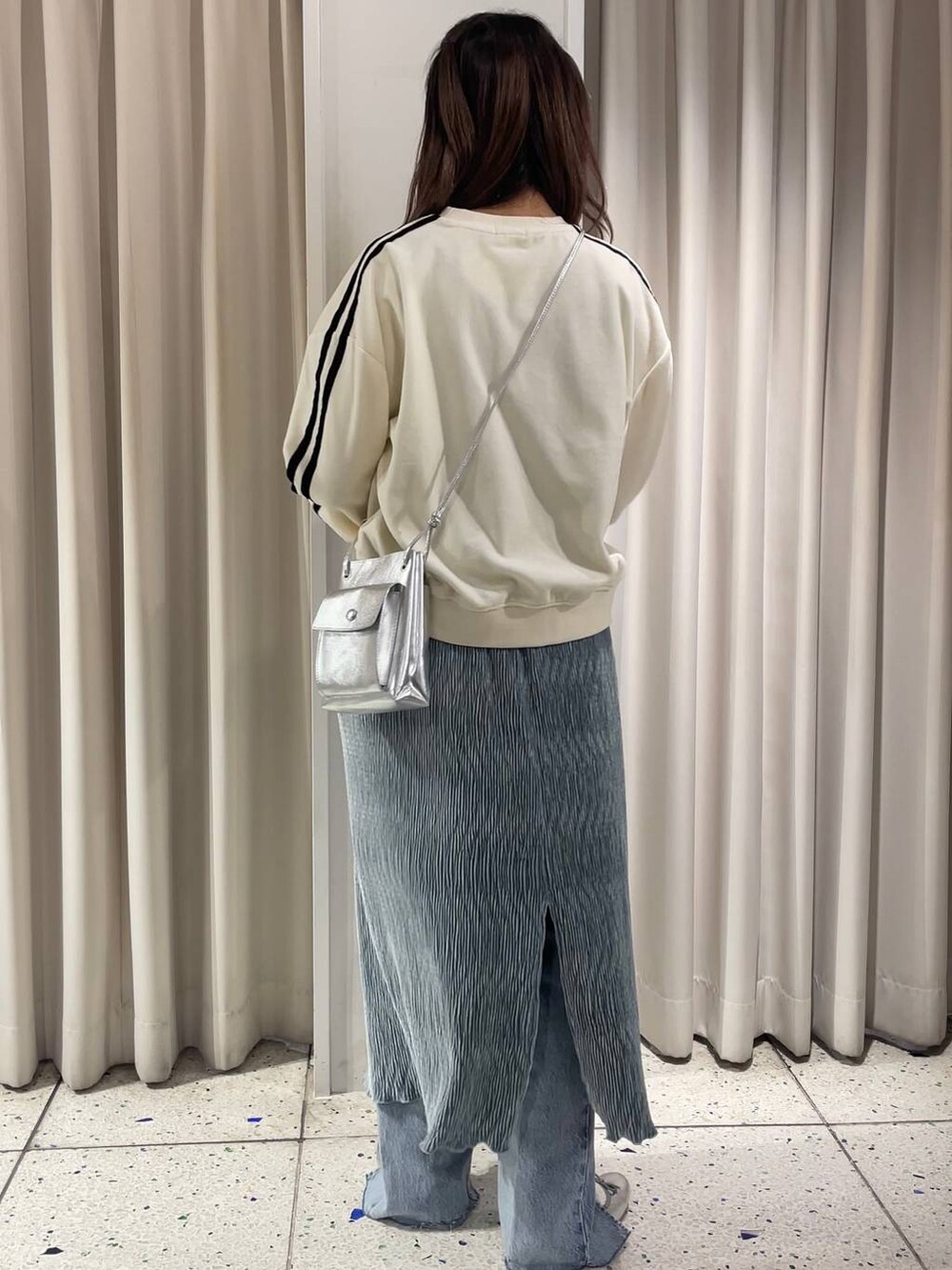 グレー系のバレエシューズ、ブルー系のデニムパンツ、ホワイト系のスウェットを着用したレディースの冬コーディネートの3枚目の写真