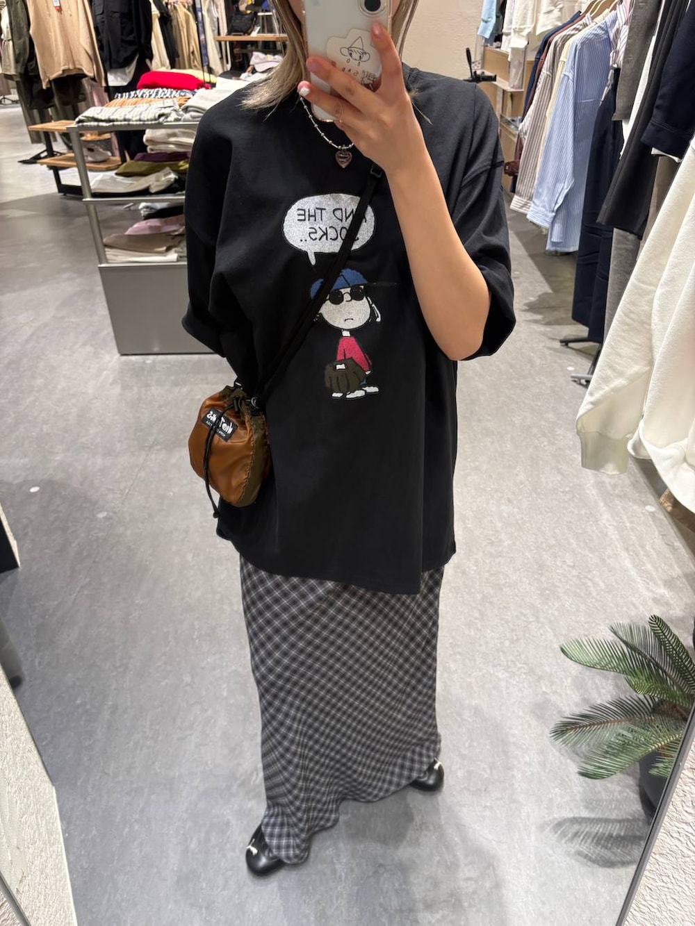 ブラウン系のショルダーバッグ、グレー系のスカート、ブラック系のTシャツ/カットソーを着用したレディースの春コーディネートの7枚目の写真