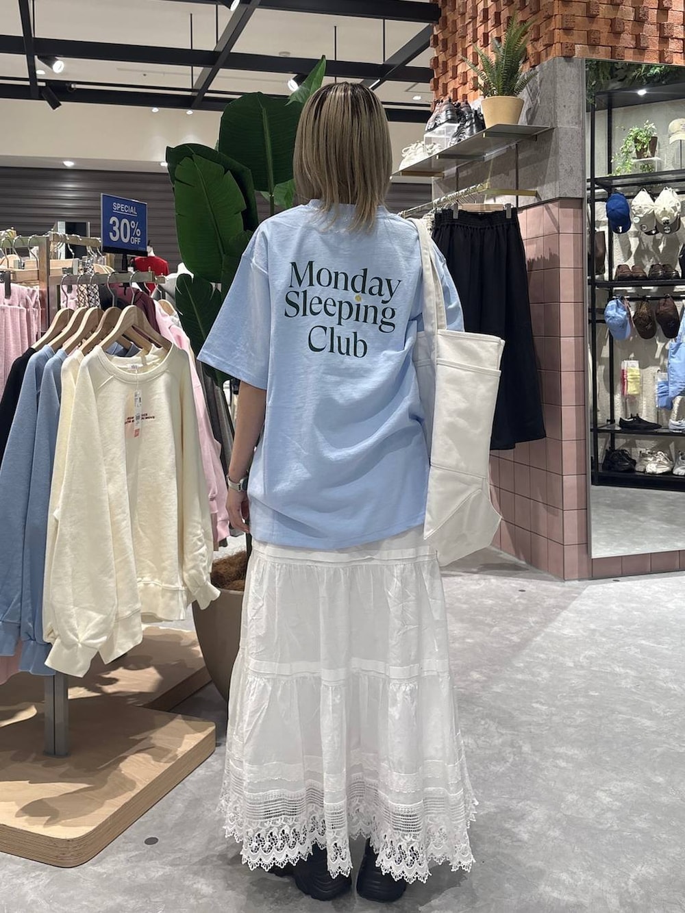 ブラック系のローファー、ブルー系のTシャツ/カットソー、ホワイト系のスカートを着用したレディースの春コーディネートの3枚目の写真