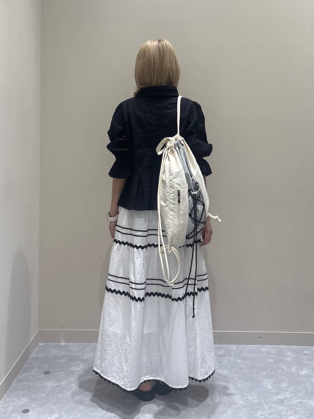 シルバー系のサンダル、ホワイト系のスカート、ブラック系のシャツ/ブラウスを着用したレディースの夏コーディネートの3枚目の写真