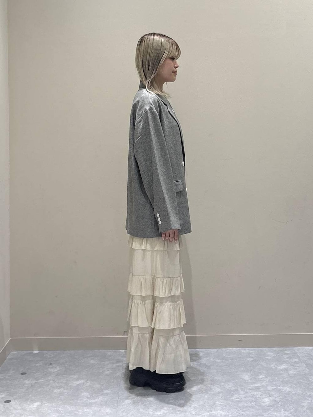 グレー系のテーラードジャケット、ブラック系のローファー、ブルー系のTシャツ/カットソーを着用したレディースの春コーディネートの4枚目の写真