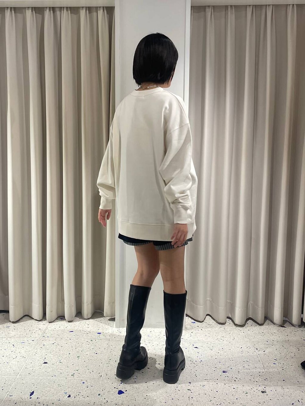 ブルー系のその他パンツ、ブラック系のブーツ、ホワイト系のスウェットを着用したレディースの秋コーディネートの2枚目の写真