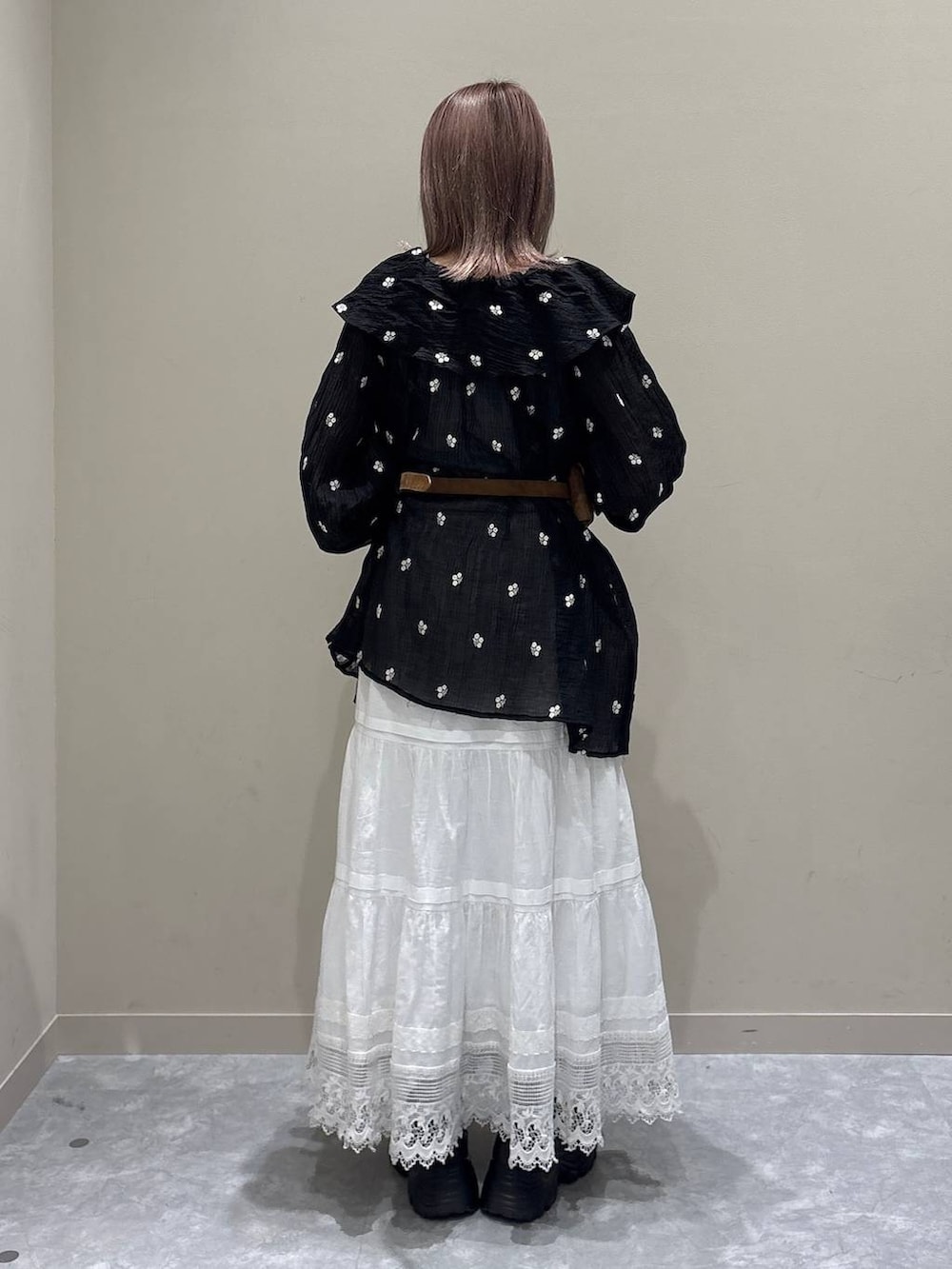 ブラウン系のローファー、ホワイト系のスカート、ブラック系のワンピースを着用したレディースの春コーディネートの3枚目の写真