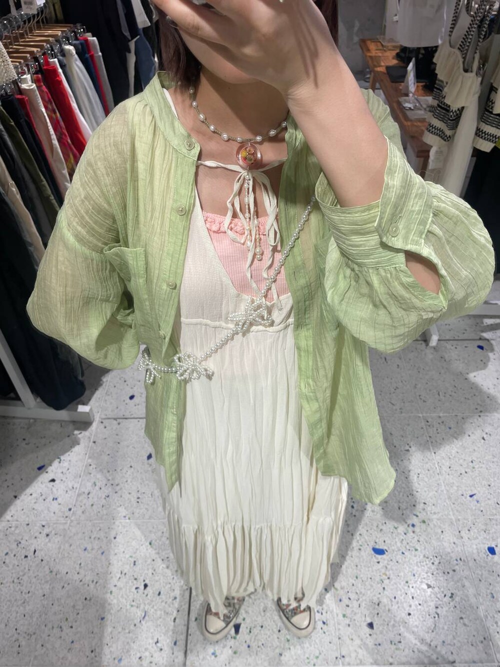 ホワイト系のカーゴパンツ、ピンク系のキャミソール、グリーン系のシャツ/ブラウスを着用したレディースの春コーディネートの5枚目の写真