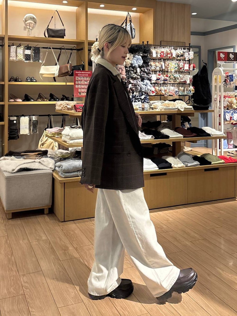ブラック系のショルダーバッグ、ベージュ系のベスト、ベージュ系のデニムパンツを着用したレディースの秋コーディネートの4枚目の写真