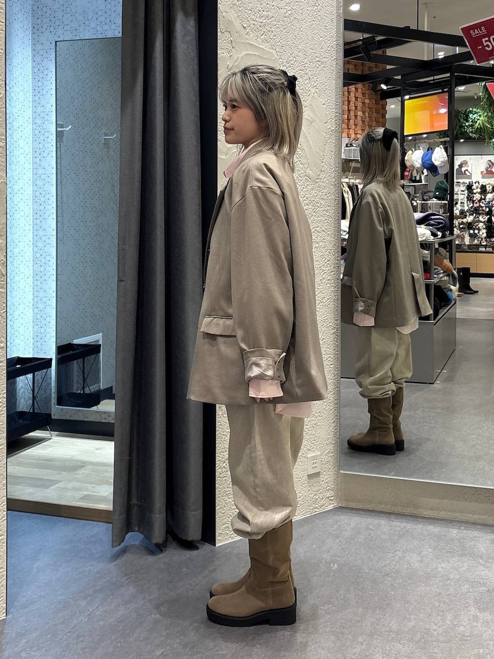 ベージュ系のデニムパンツ、ベージュ系のブーツ、ベージュ系のテーラードジャケットを着用したレディースの冬コーディネートの2枚目の写真