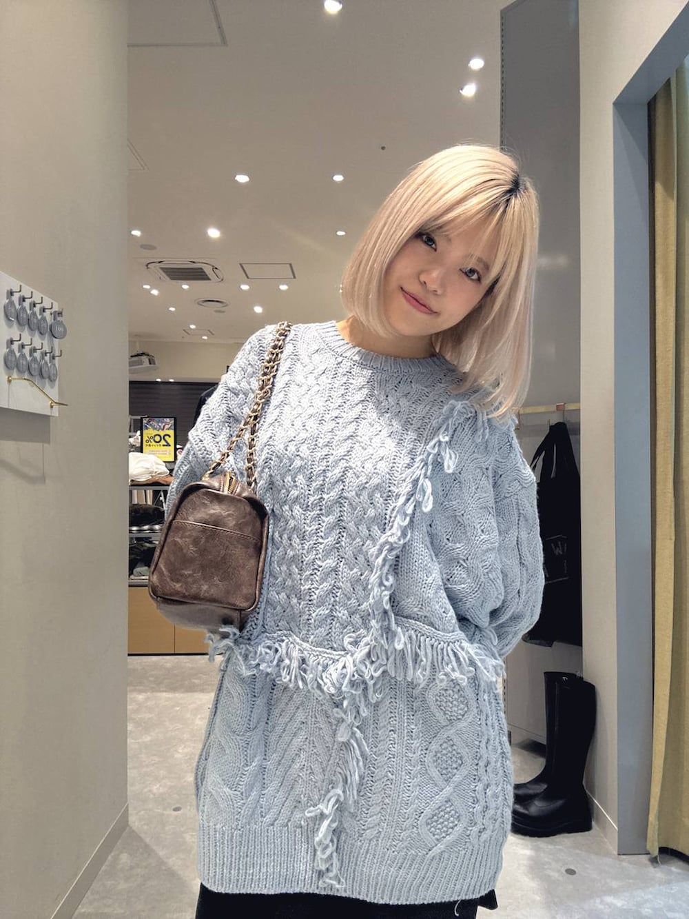 グレー系のその他パンツ、ブルー系のニット/セーター、ブラウン系のブーツを着用したレディースの冬コーディネートの6枚目の写真