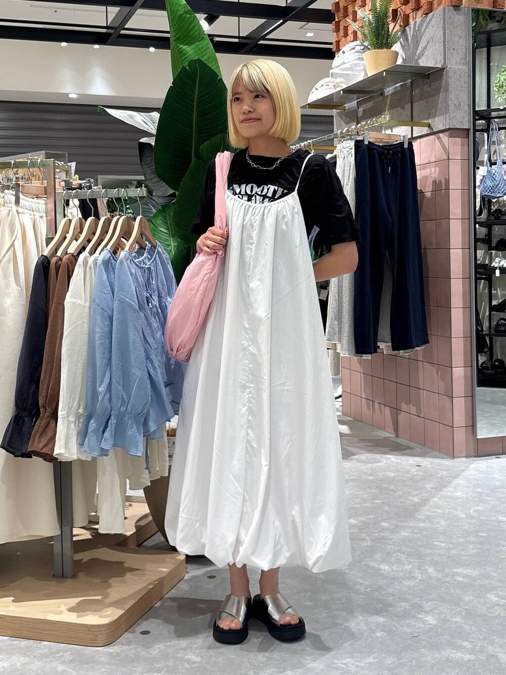 シルバー系のサンダル、ピンク系のトートバッグ、ホワイト系のワンピースを着用したレディースの夏コーディネートの4枚目の写真