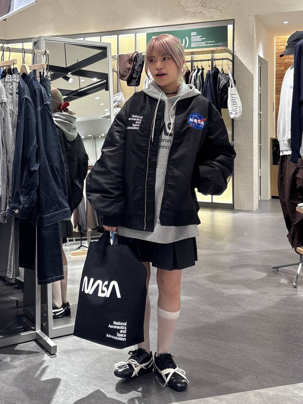 グレー系のスカート、グレー系のTシャツ/カットソー、ブラック系のブルゾンを着用したレディースの秋コーディネートの6枚目の写真