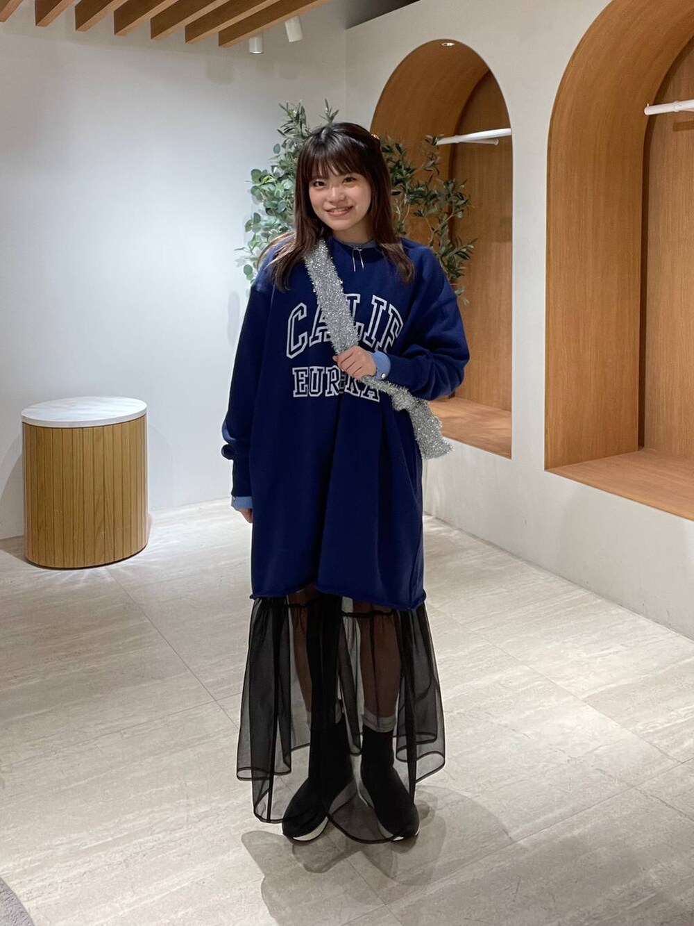 ブルー系のニット/セーター、ブラック系のショルダーバッグ、シルバー系のショルダーバッグを着用したレディースの冬コーディネートの2枚目の写真