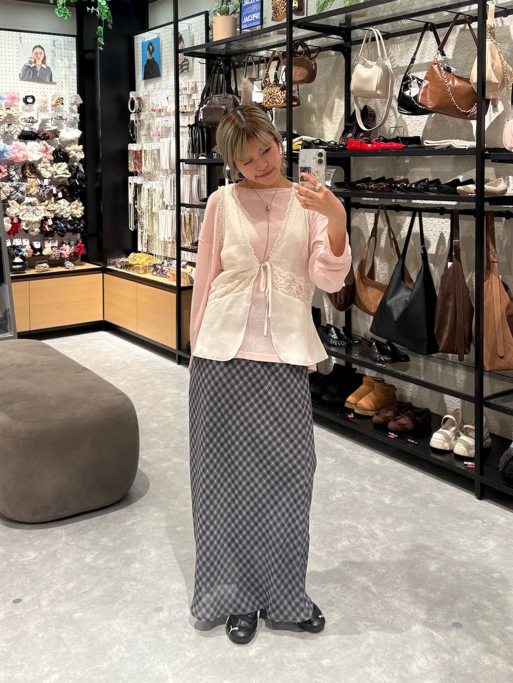 ピンク系のTシャツ/カットソー、ホワイト系のベスト、グレー系のスカートを着用したレディースの冬コーディネートの3枚目の写真