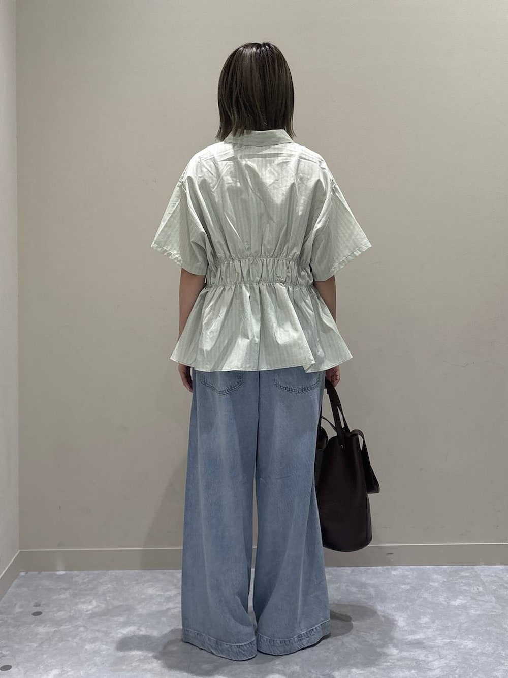 シルバー系のサンダル、ブラウン系のショルダーバッグ、グリーン系のTシャツ/カットソーを着用したレディースの春コーディネートの3枚目の写真
