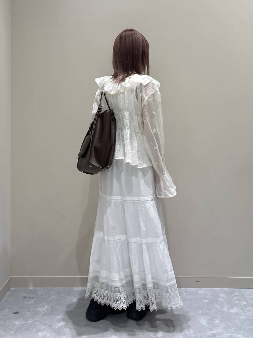ブラウン系のローファー、ブラウン系のトートバッグ、ホワイト系のスカートを着用したレディースの春コーディネートの4枚目の写真