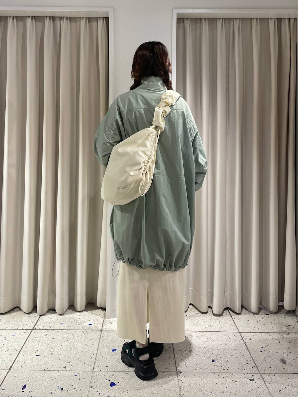 ホワイト系のスカート、グリーン系のサンダル、ホワイト系のショルダーバッグを着用したレディースの春コーディネートの3枚目の写真