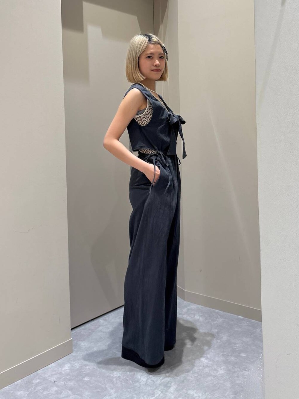 ホワイト系のTシャツ/カットソー、ブラック系のサンダル、グレー系のサロペット/オーバーオールを着用したレディースの春コーディネートの4枚目の写真