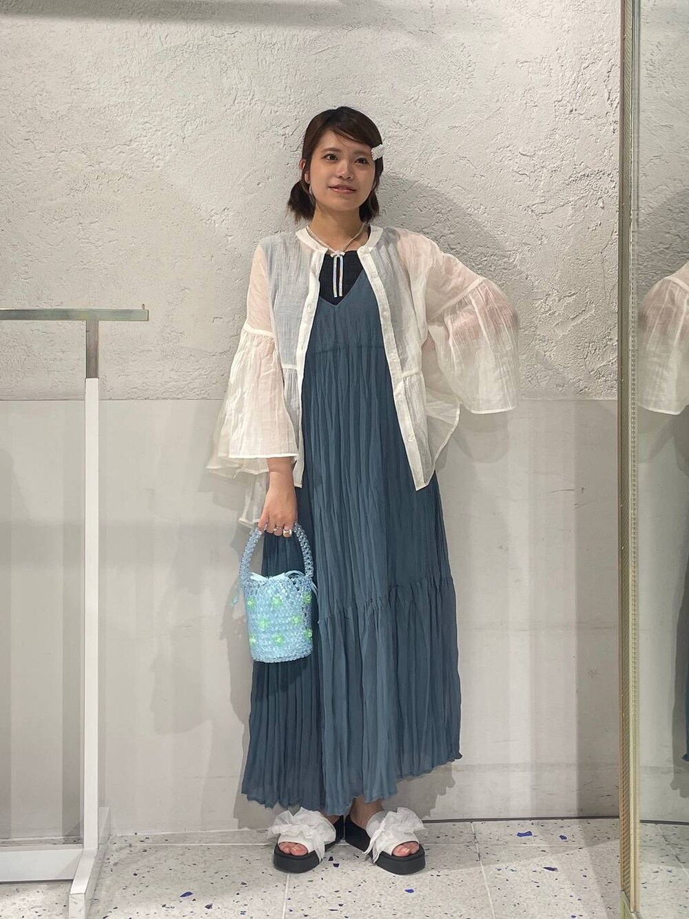 ホワイト系のサンダル、ブルー系のワンピース、ブルー系のハンドバッグを着用したレディースの夏コーディネートの3枚目の写真