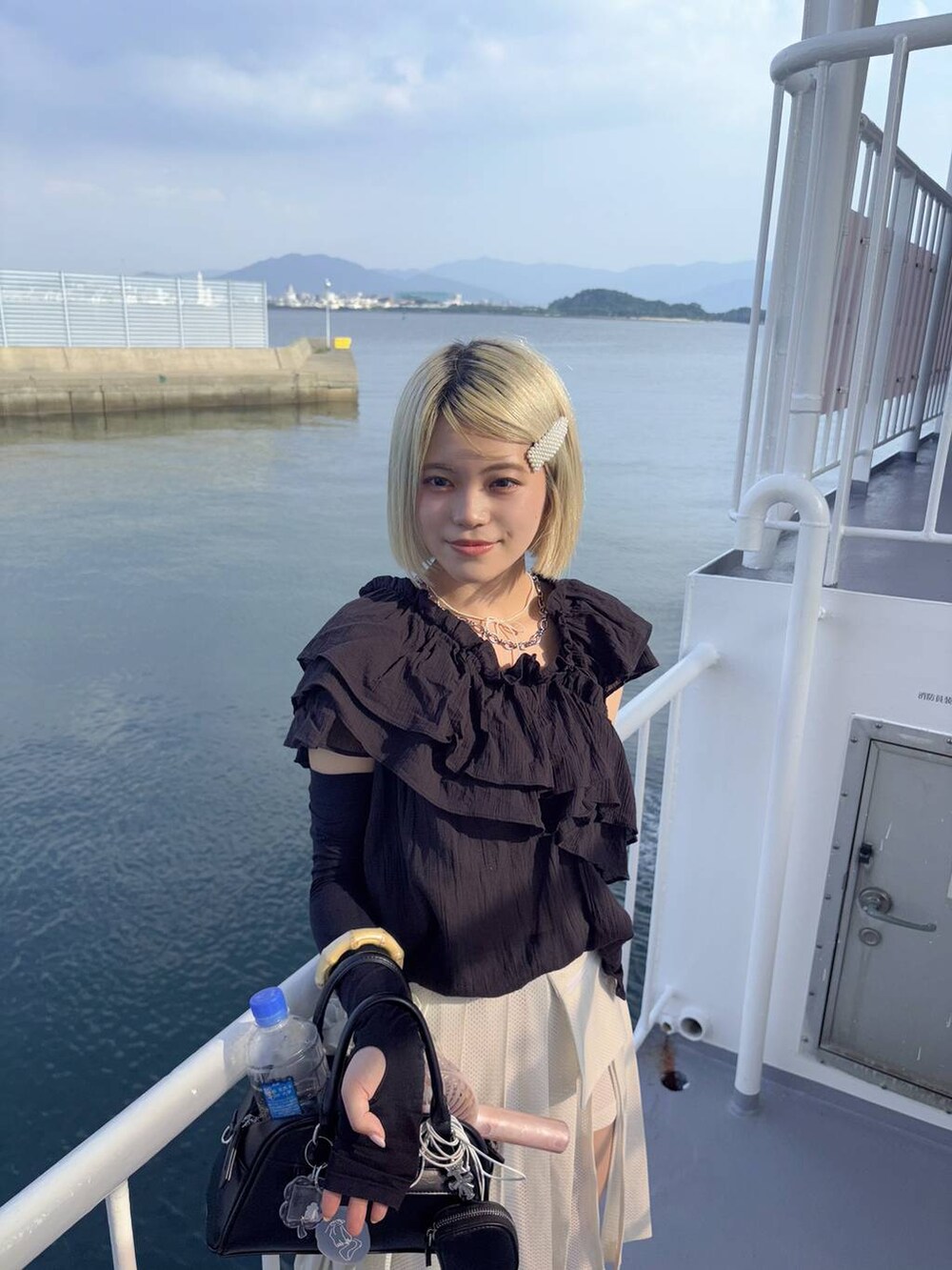 ブラック系のシャツ/ブラウス、ブラック系のショルダーバッグを着用したレディースの夏コーディネートの2枚目の写真