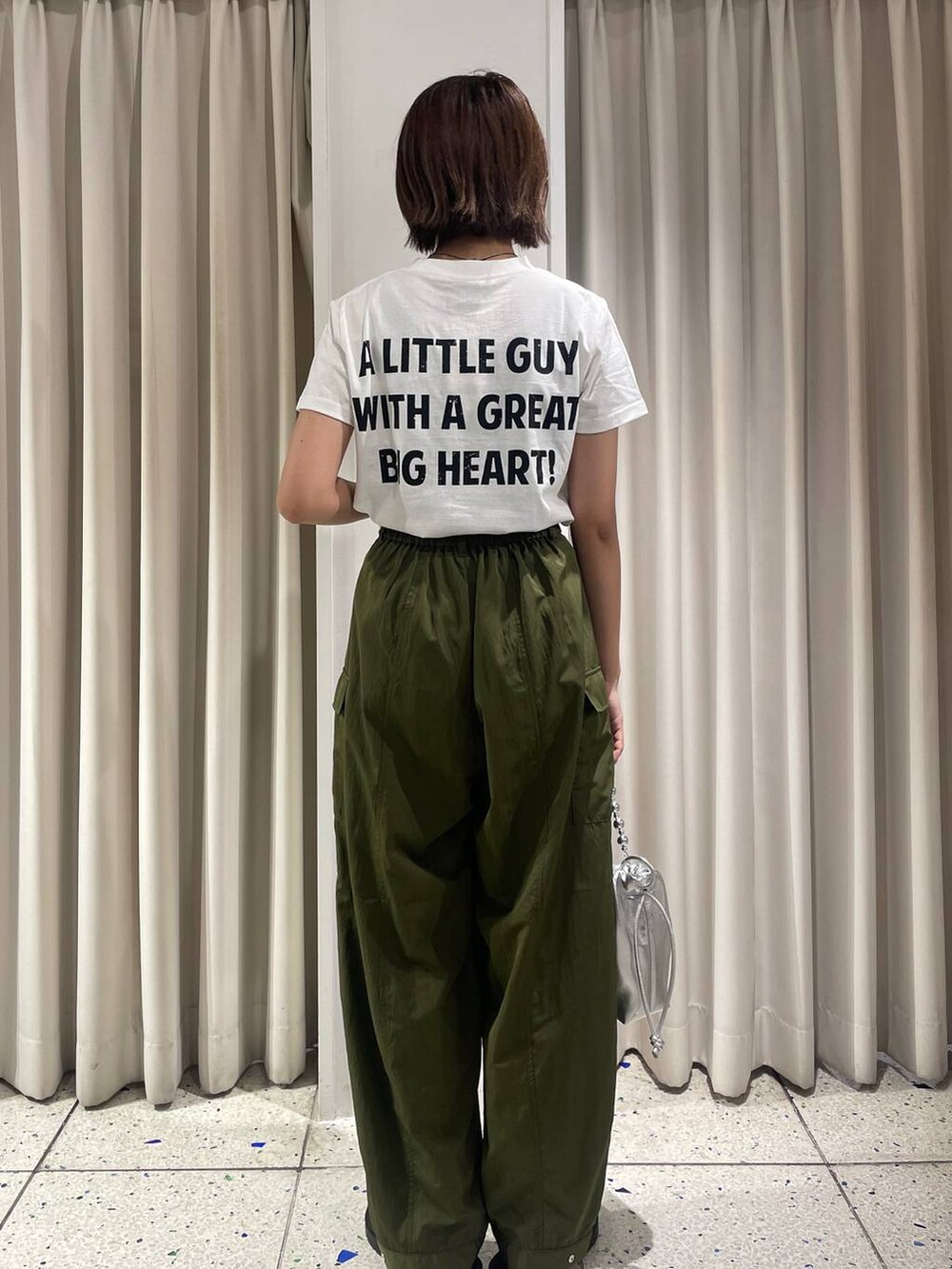 グリーン系のカーゴパンツ、ホワイト系のTシャツ/カットソー、シルバー系のスニーカーを着用したレディースの夏コーディネートの3枚目の写真