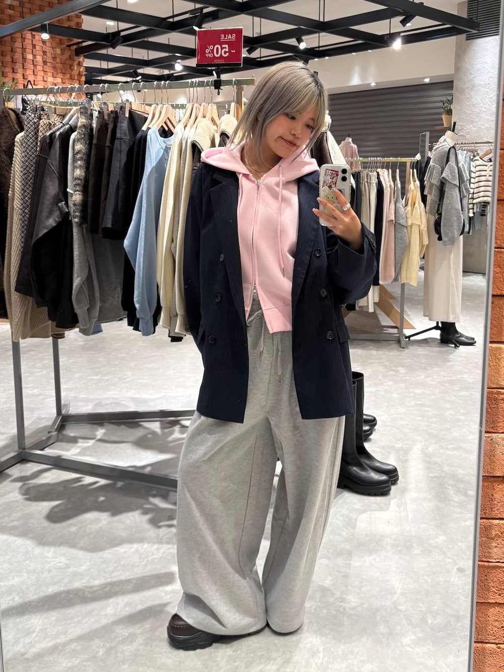 ピンク系のパーカー、ブラウン系のローファー、ブルー系のテーラードジャケットを着用したレディースの春コーディネートの2枚目の写真