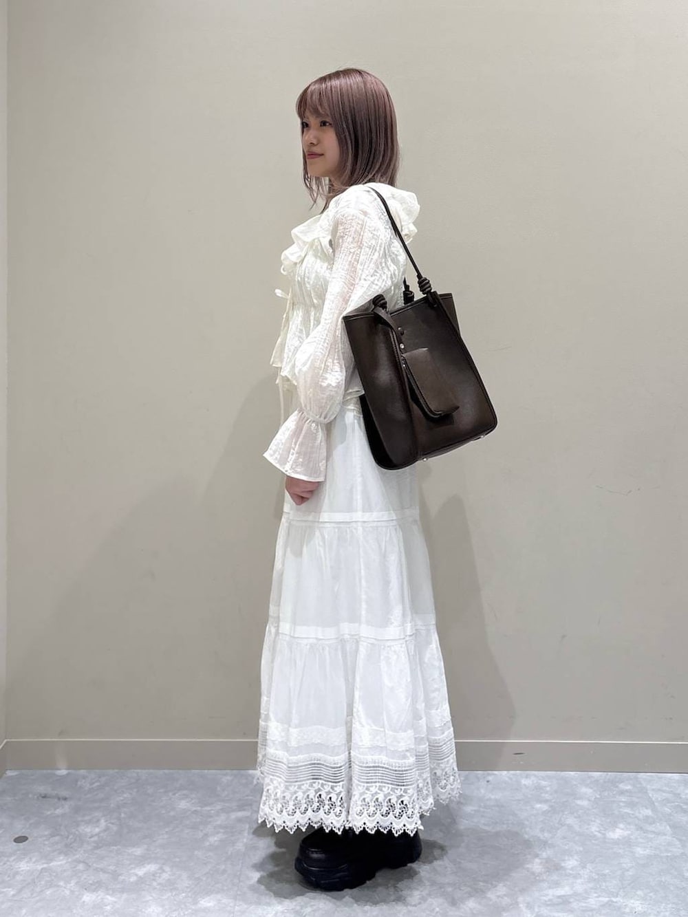 ブラウン系のローファー、ブラウン系のトートバッグ、ホワイト系のスカートを着用したレディースの春コーディネートの3枚目の写真