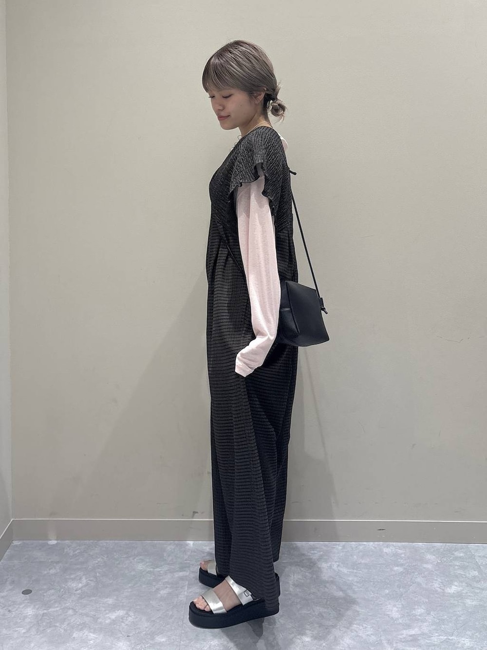 ブラウン系のサロペット/オーバーオール、ピンク系のTシャツ/カットソー、シルバー系のサンダルを着用したレディースの春コーディネートの2枚目の写真