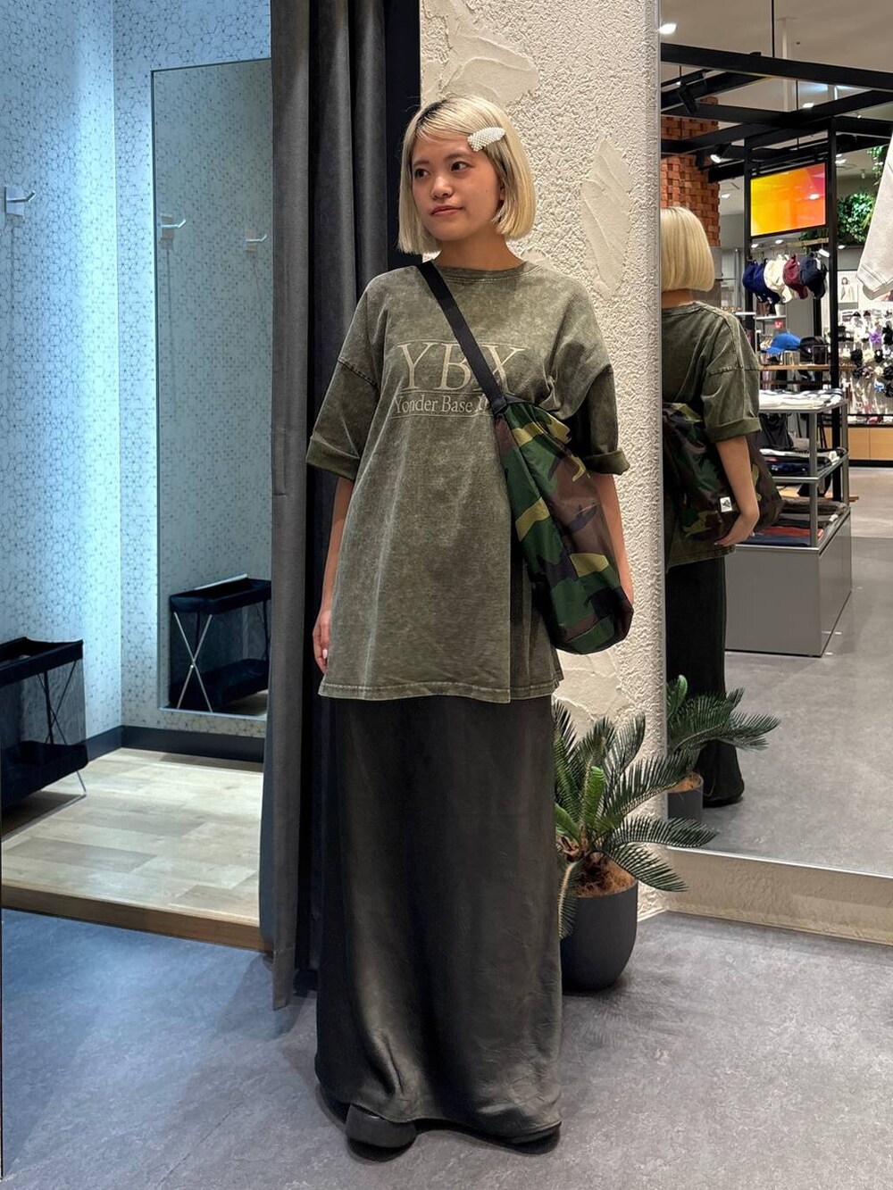 グレー系のスカート、グリーン系のショルダーバッグ、グリーン系のTシャツ/カットソーを着用したレディースの夏コーディネートの5枚目の写真