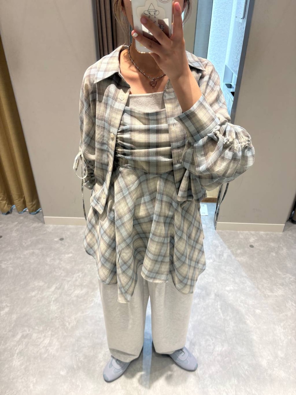 グレー系のスウェットパンツ、シルバー系のタンクトップ、ブルー系のスニーカーを着用したレディースの春コーディネートの6枚目の写真