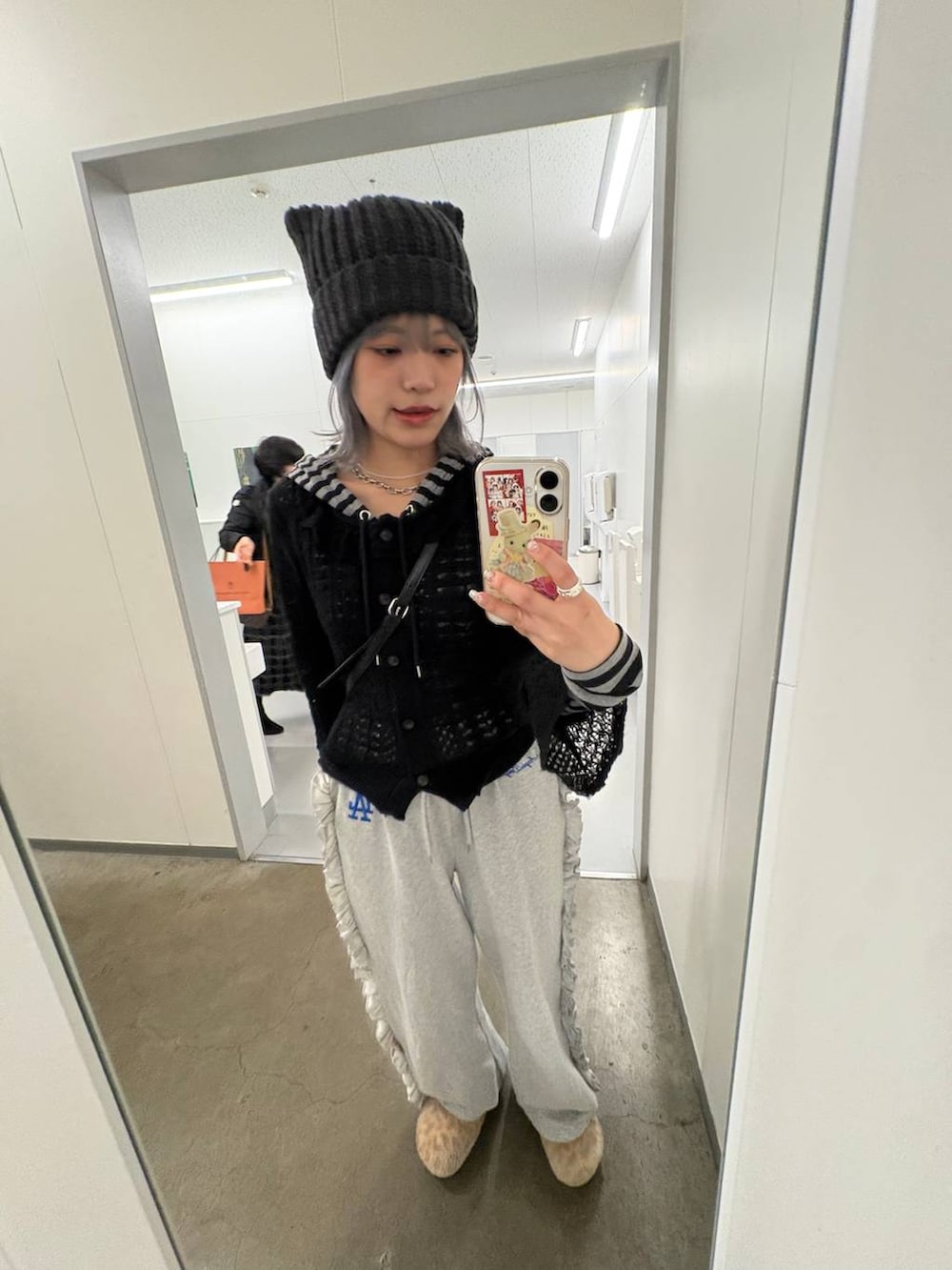 ブラック系のカーディガン/ボレロ、グレー系のニットキャップ/ビーニーを着用したレディースの冬コーディネートの2枚目の写真