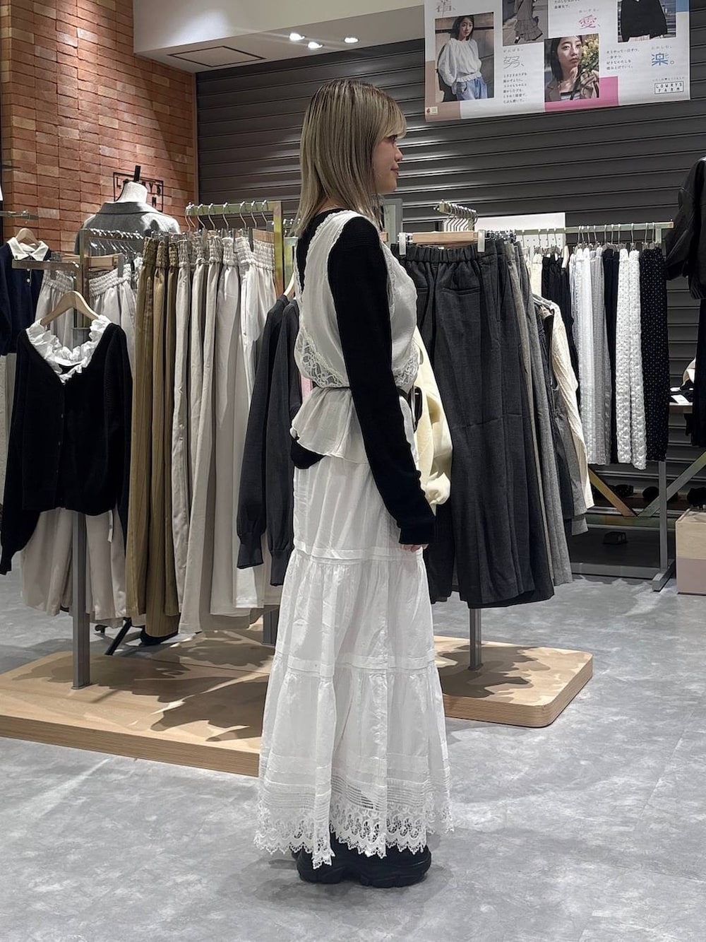 ブラック系のニット/セーター、ブラック系のローファー、ホワイト系のベストを着用したレディースの春コーディネートの4枚目の写真