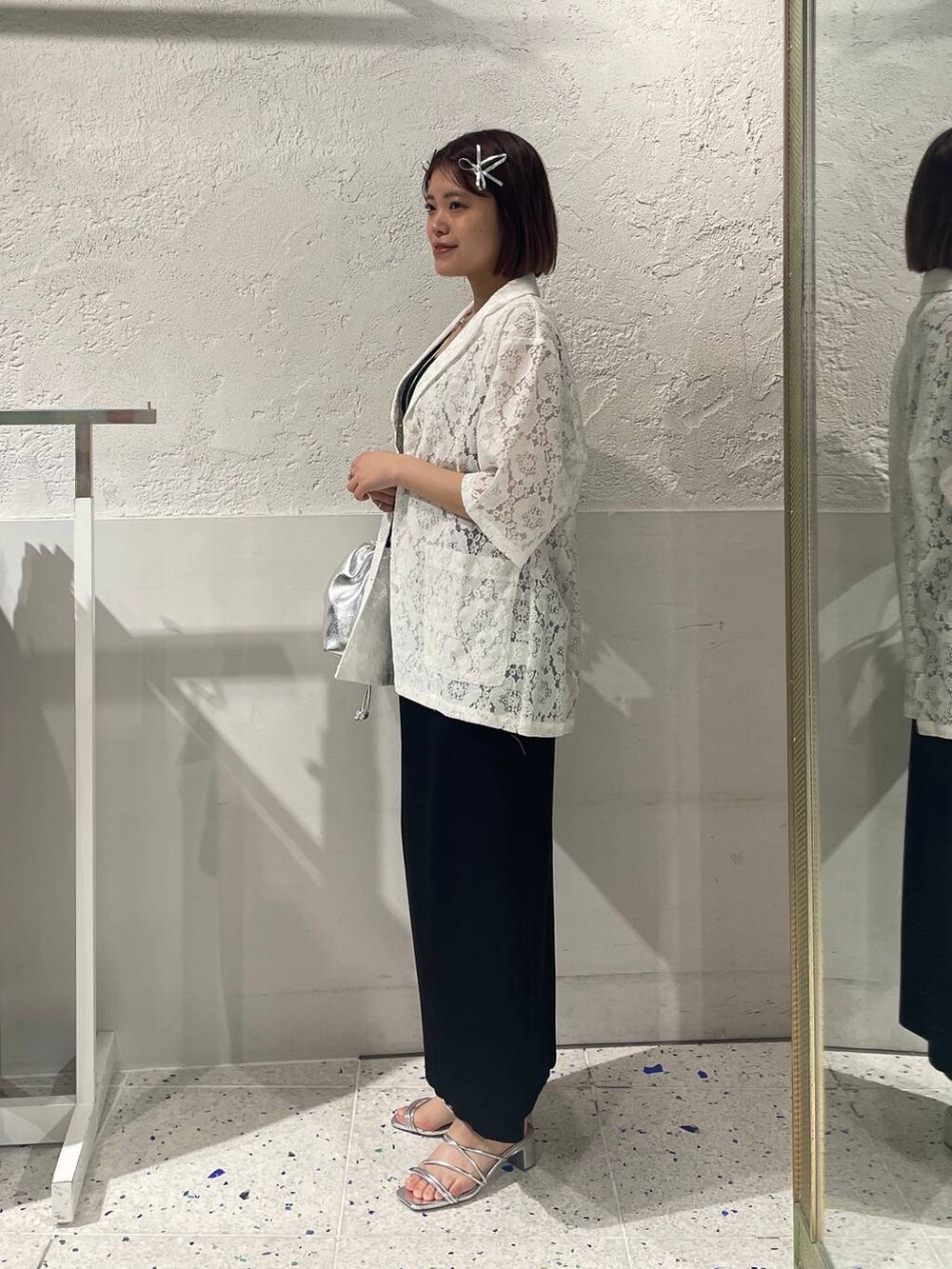 ブラック系のスカート、シルバー系のサンダル、ホワイト系のシャツ/ブラウスを着用したレディースの春コーディネートの2枚目の写真