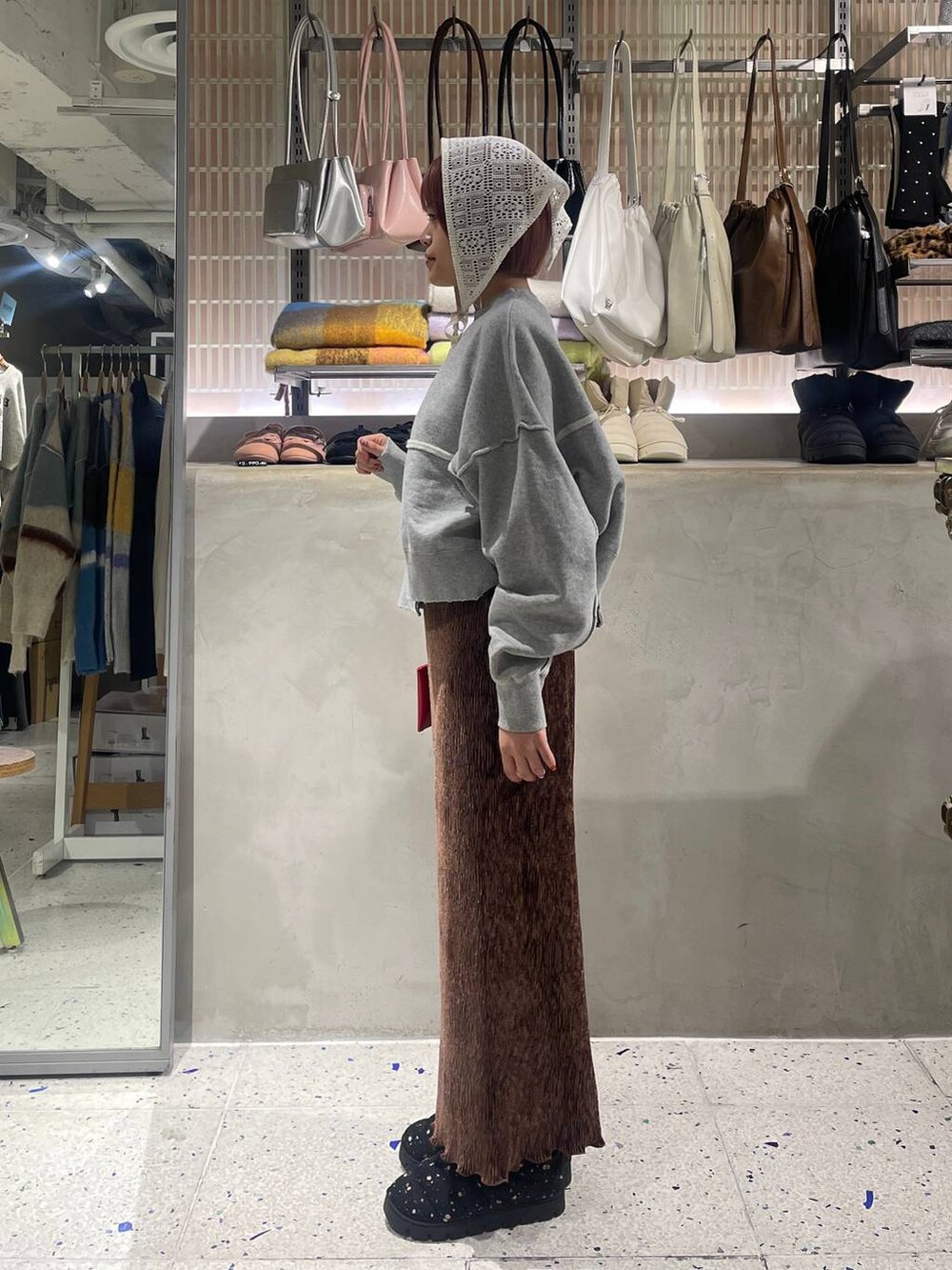 ブラウン系のスカート、グレー系のスウェット、その他のブーツを着用したレディースの冬コーディネートの4枚目の写真