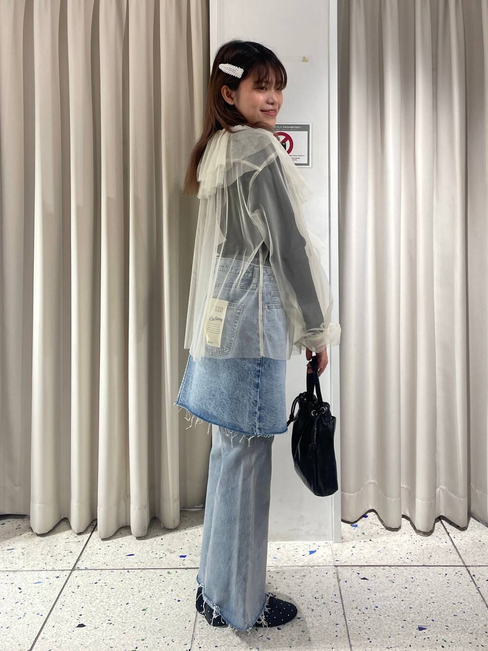 グレー系のニット/セーター、ブルー系のデニムパンツ、ブルー系のスカートを着用したレディースの冬コーディネートの3枚目の写真