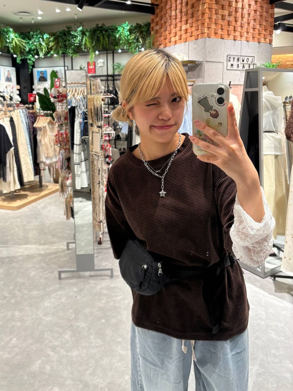 ブラウン系のTシャツ/カットソー、ブルー系のデニムパンツ、ブラック系のボディバッグ/ウエストポーチを着用したレディースの夏コーディネートの2枚目の写真