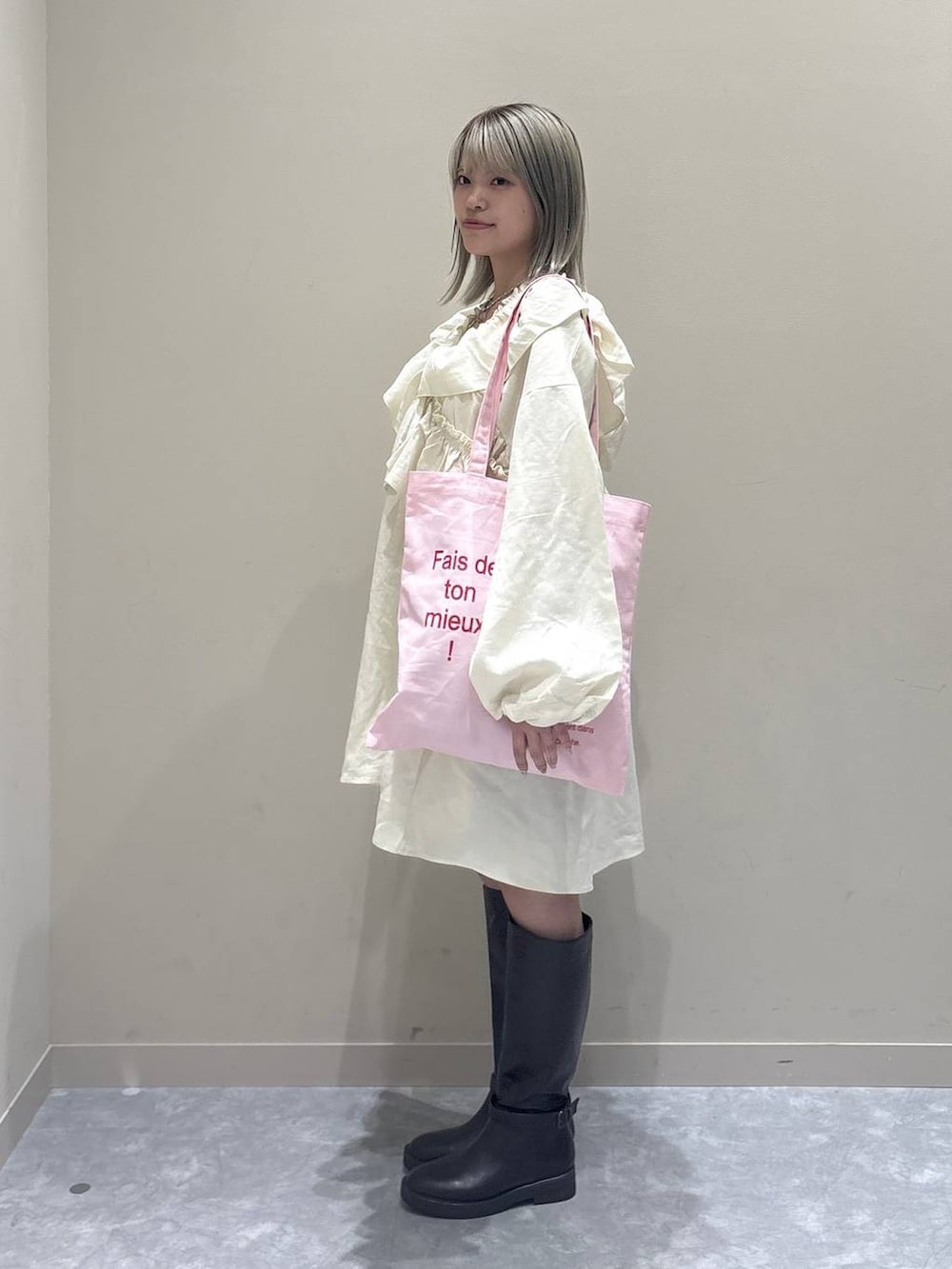 ブラック系のその他パンツ、ブラウン系のブーツ、ピンク系のトートバッグを着用したレディースの冬コーディネートの4枚目の写真