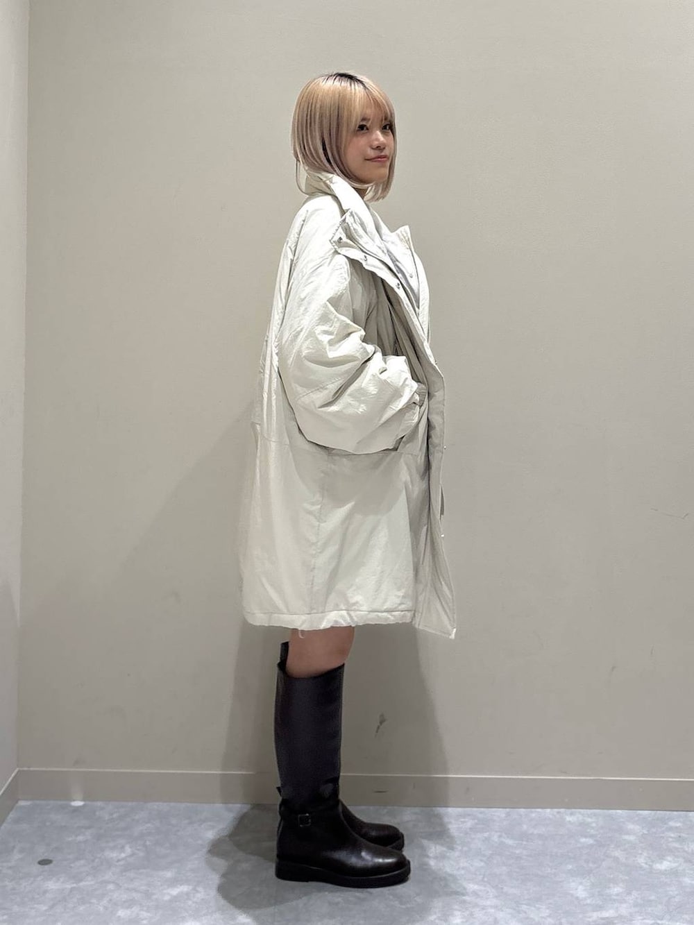 ブルー系のカーディガン/ボレロ、ホワイト系のブルゾン、ブラウン系のブーツを着用したレディースの秋コーディネートの2枚目の写真