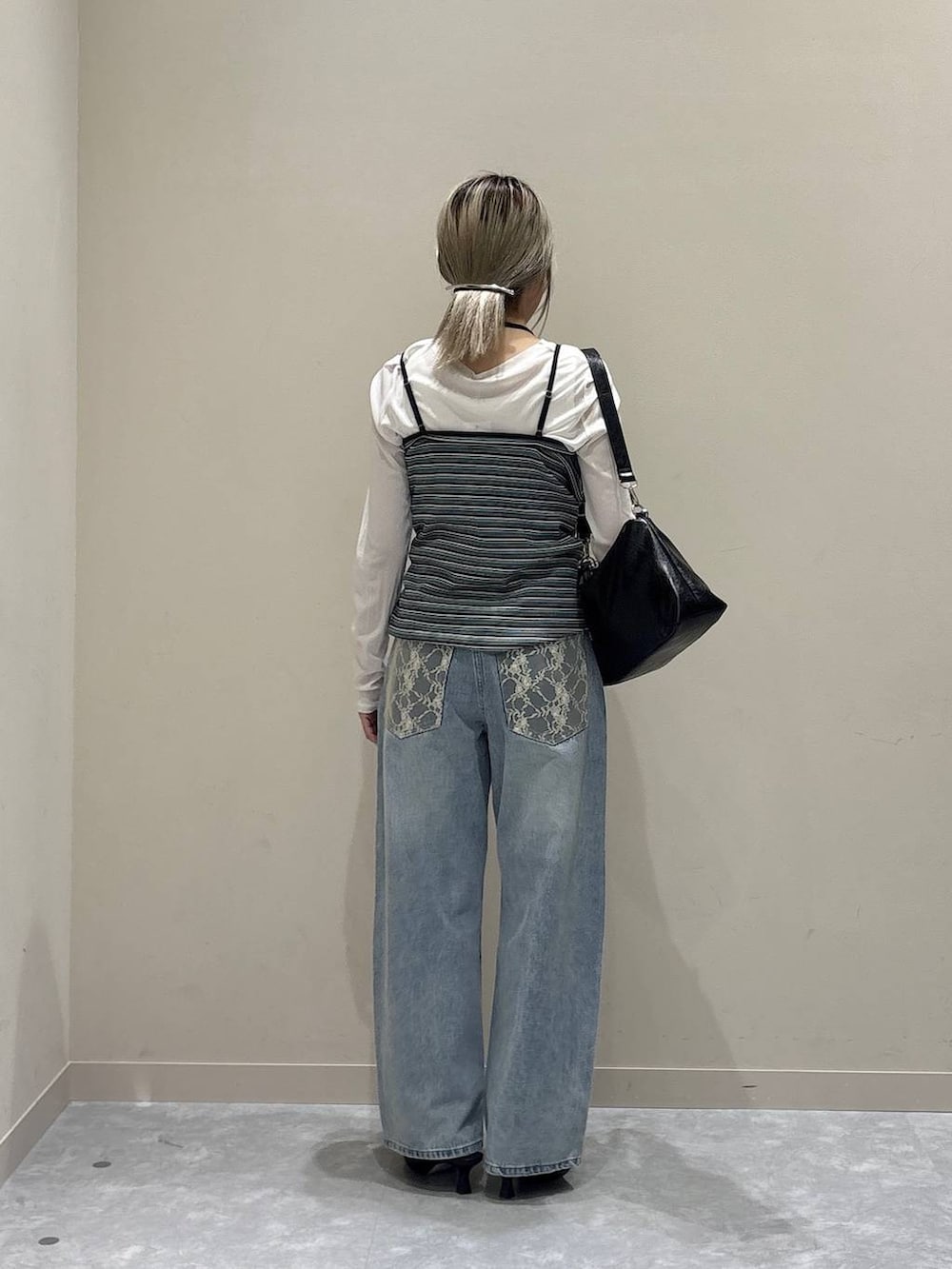 ブルー系のデニムパンツ、ホワイト系のTシャツ/カットソー、ブラック系のショルダーバッグを着用したレディースの春コーディネートの3枚目の写真