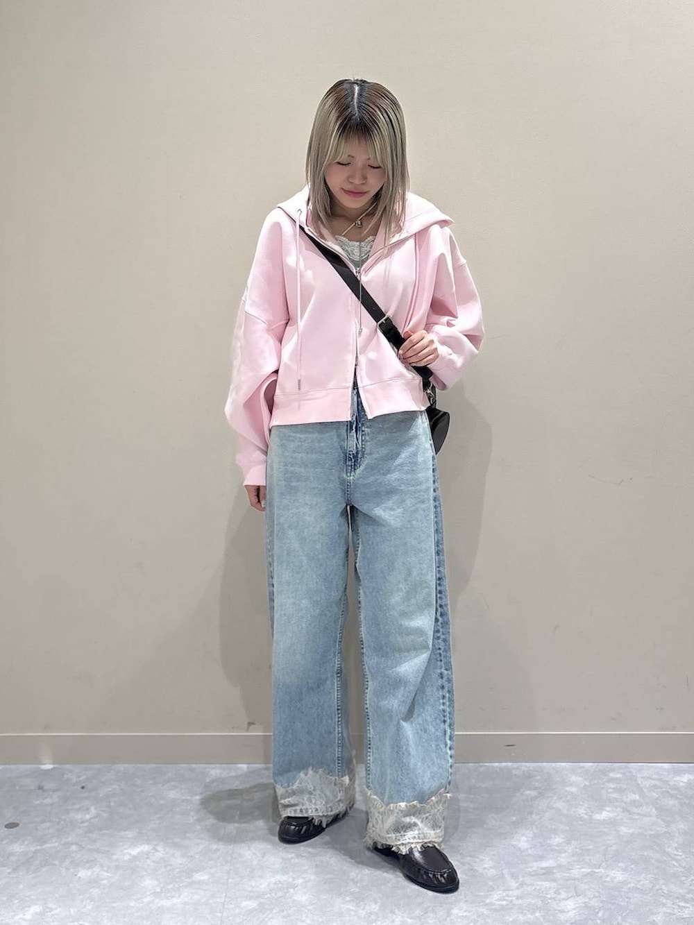 ピンク系のパーカー、ブルー系のデニムパンツ、ブラウン系のローファーを着用したレディースの春コーディネートの5枚目の写真