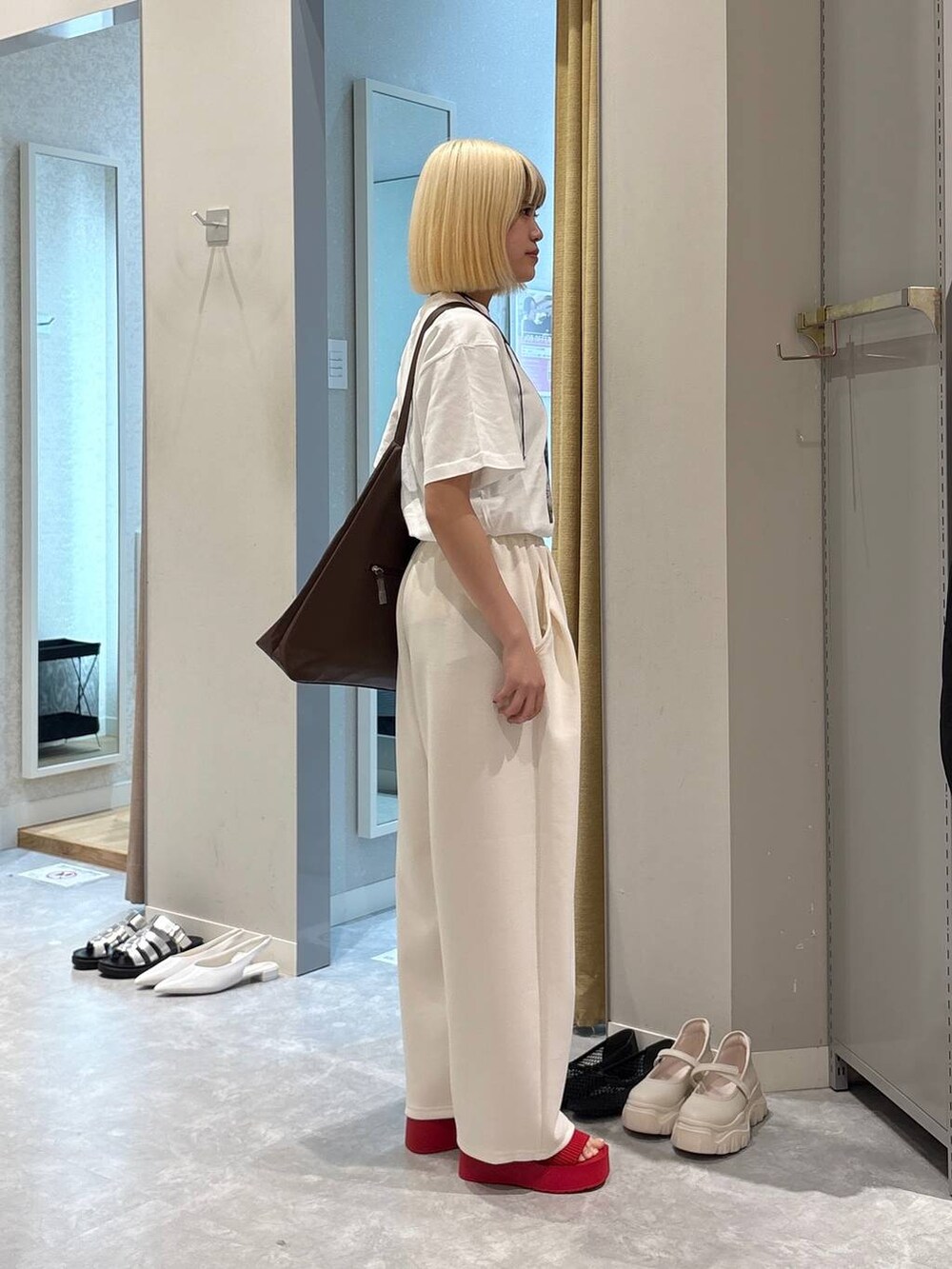 ブラウン系のショルダーバッグ、レッド系のサンダル、ホワイト系のTシャツ/カットソーを着用したレディースの春コーディネートの2枚目の写真