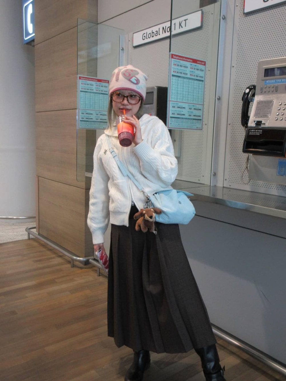 ブラウン系のスカート、ブラック系のニット/セーター、ブラック系のブーツを着用したレディースの冬コーディネートの2枚目の写真