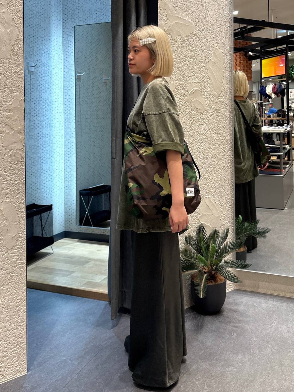 グレー系のスカート、グリーン系のショルダーバッグ、グリーン系のTシャツ/カットソーを着用したレディースの夏コーディネートの2枚目の写真