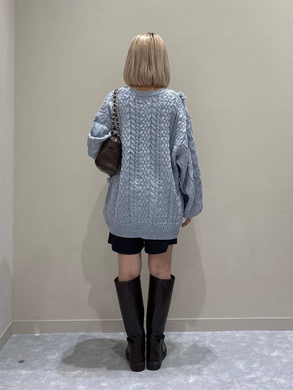 グレー系のその他パンツ、ブルー系のニット/セーター、ブラウン系のブーツを着用したレディースの冬コーディネートの3枚目の写真