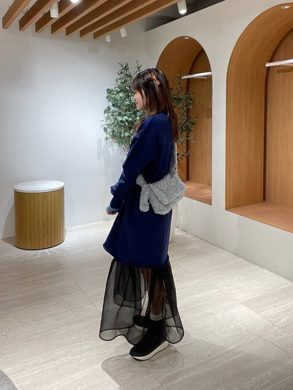 ブルー系のニット/セーター、ブラック系のショルダーバッグ、シルバー系のショルダーバッグを着用したレディースの冬コーディネートの5枚目の写真