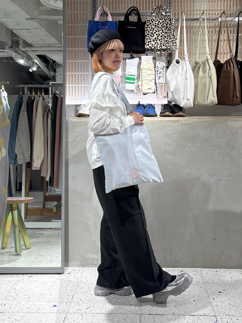 グレー系のスラックス、その他のトートバッグ、ホワイト系のTシャツ/カットソーを着用したレディースの春コーディネートの4枚目の写真